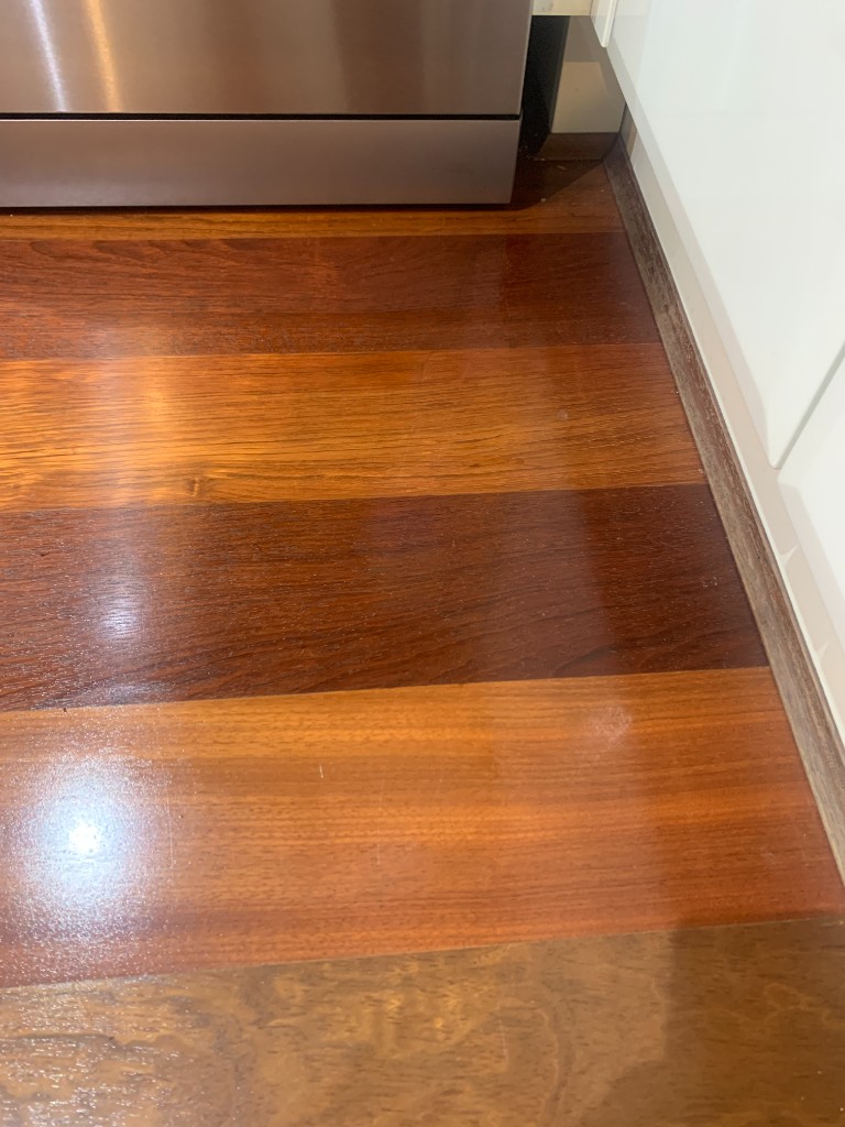 Same timber floor after localised scratch repair and sheen blending